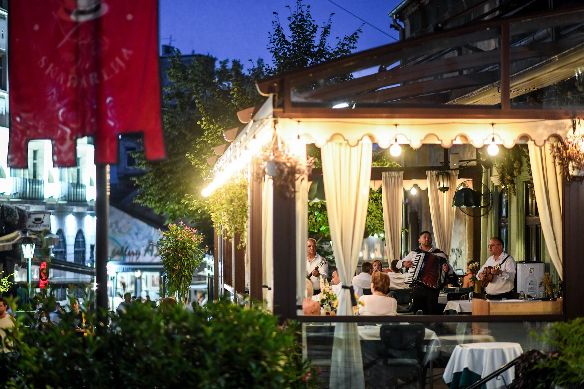Bašta restorana Zlatni bokal u Skadarliji u sumrak, tamburaši sviraju za goste